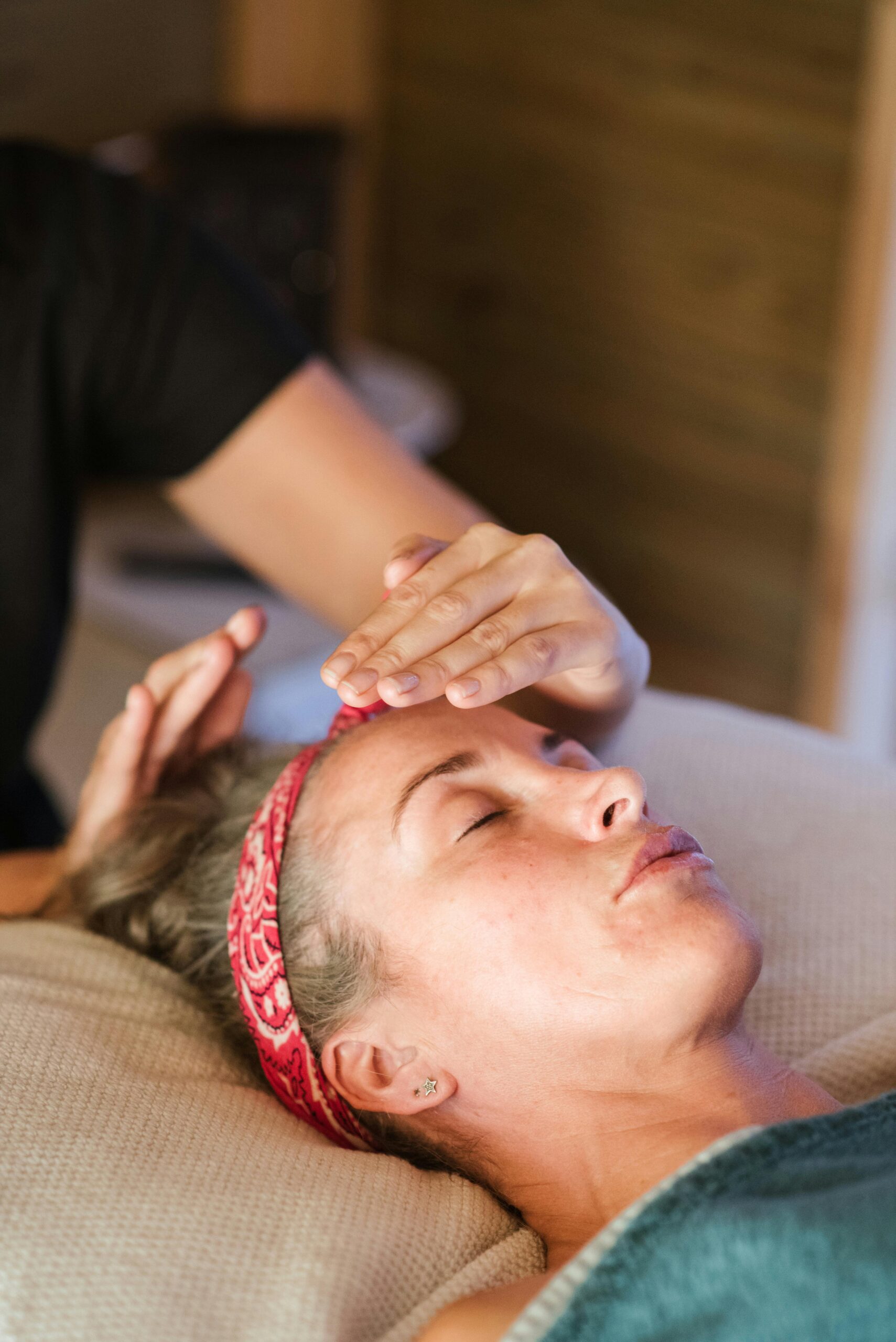 A woman enjoying a peaceful reiki session in a cozy spa setting for ultimate relaxation.
